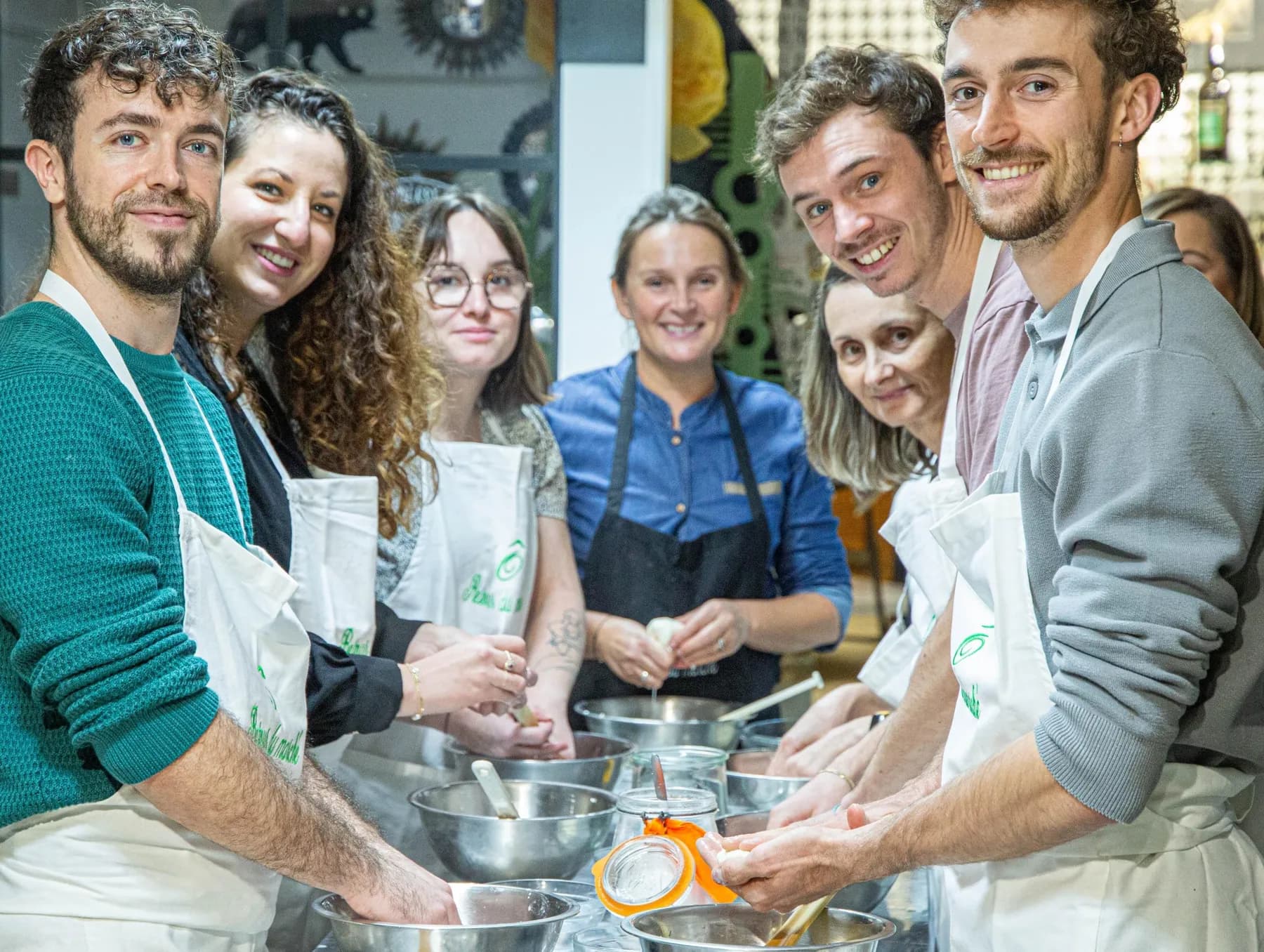 Un groupe cuisine un repas complet ensemble lors d'un atelier chez Ô Retour du Marché à Lyon